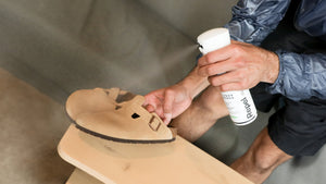 Person spraying Birkenstock Bostons with Repel Spray
